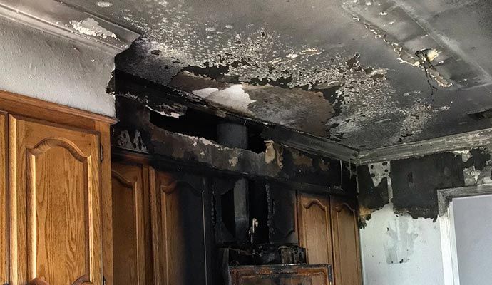 Smoke-damaged kitchen walls, ceiling and cabinets Fire-damaged kitchen showing soot-stained walls, ceiling and cabinets.
