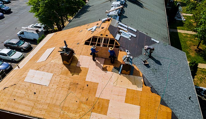 several workers installing new roofing materials