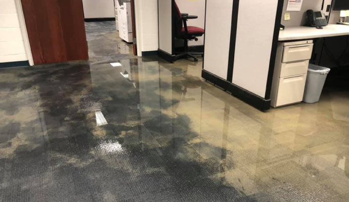 Flooded office space with water covering the carpeted floor