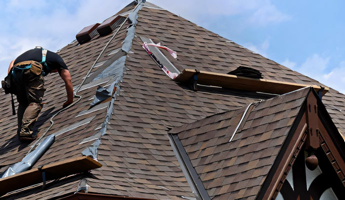 A person repairing a damaged roof